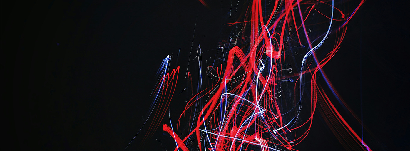Abstrakt foto av røde lysstråler med svart bakgrunn.