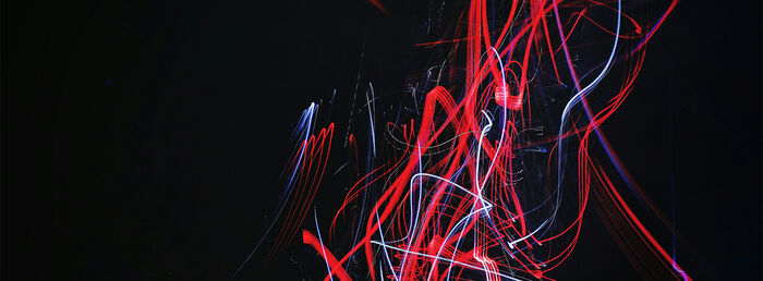 Abstrakt foto av røde lysstråler med svart bakgrunn.