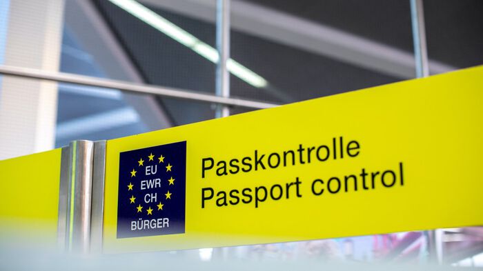 Photo of an airport sign that says "Passkontrolle / Passport control" with an EU logo