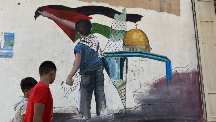 Graffiti in the streets of Nahr el-Bared Camp in Lebanon of a young boy waving the flag of Palestine in front of the Dome of the Rock.