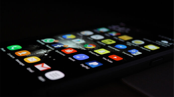 Man ser alle appene på skjermen til en smarttelefon og skjermen har spor av fingreavtrykk.
