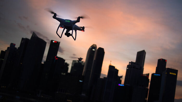 A drone in the evening with evening red sky behind and skyscrapers.