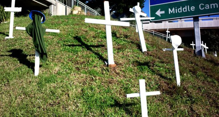 White crosses made of wood on a lawn.
