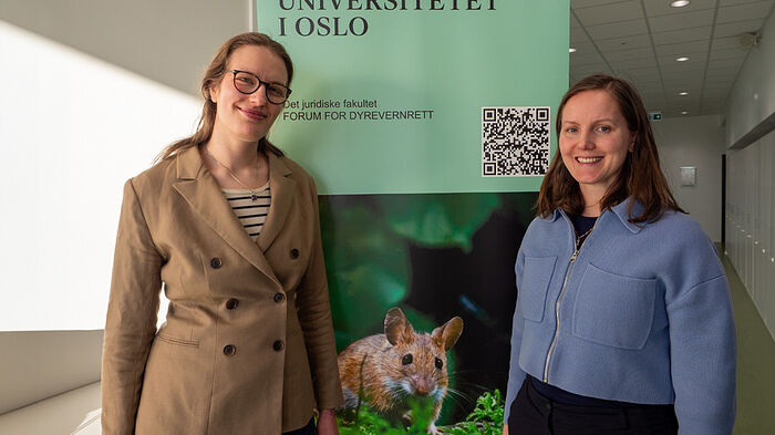Martine S.B. Lie og Annichen Kongsvik Sæteren foran forumets roll-up. Banneret er grønt og det er bilde av en mus.