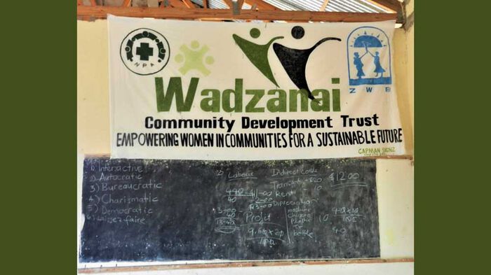 Banner with "Wasazanai Community Development Trust" hanging over a blackboard.