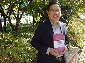 Professor Ding Peng holding the newly launched book